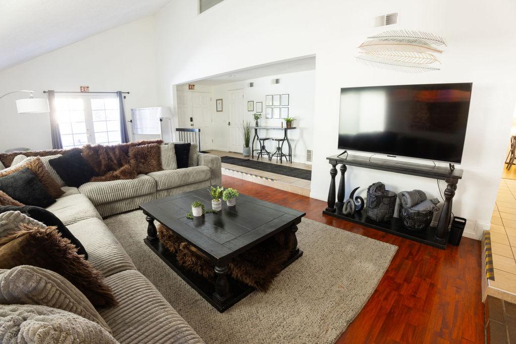 A wide gray sectional and dark wood coffee table facing the TV in the Home B living room